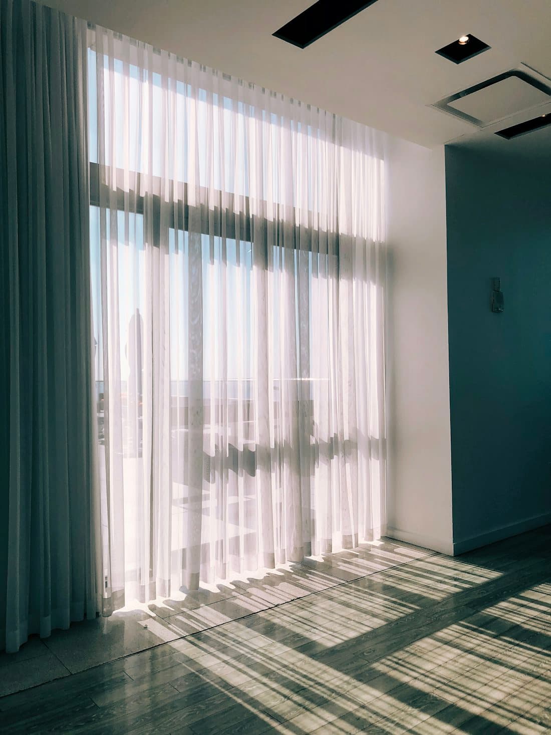 Soft morning light filtering through sheer curtains in a quiet room