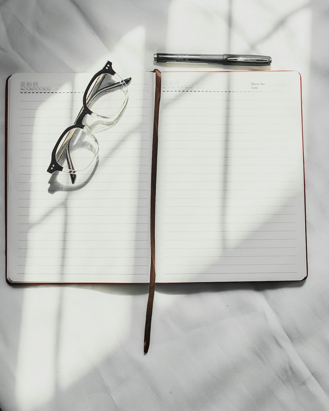 An open journal and pen resting in soft morning light