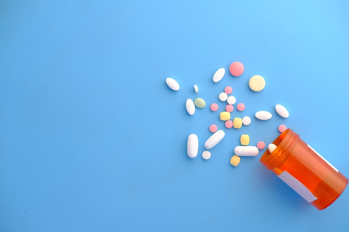 Medication capsules resting on a soft neutral surface in gentle light