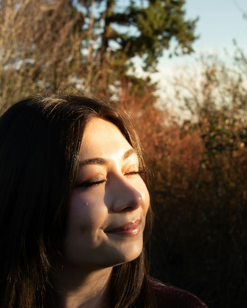 A woman resting with her eyes closed in warm afternoon light