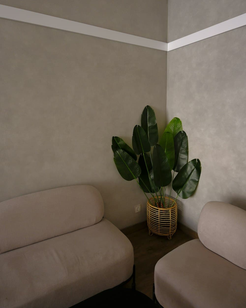 A quiet seating corner with cream armchairs and a potted plant